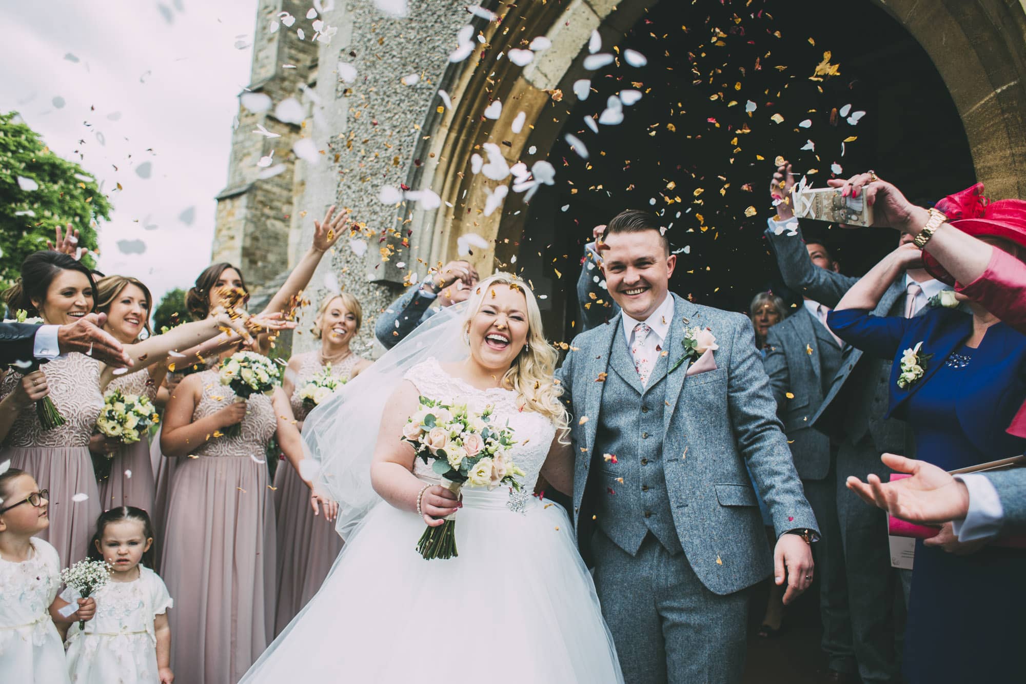 bride and groom laugh during confetti