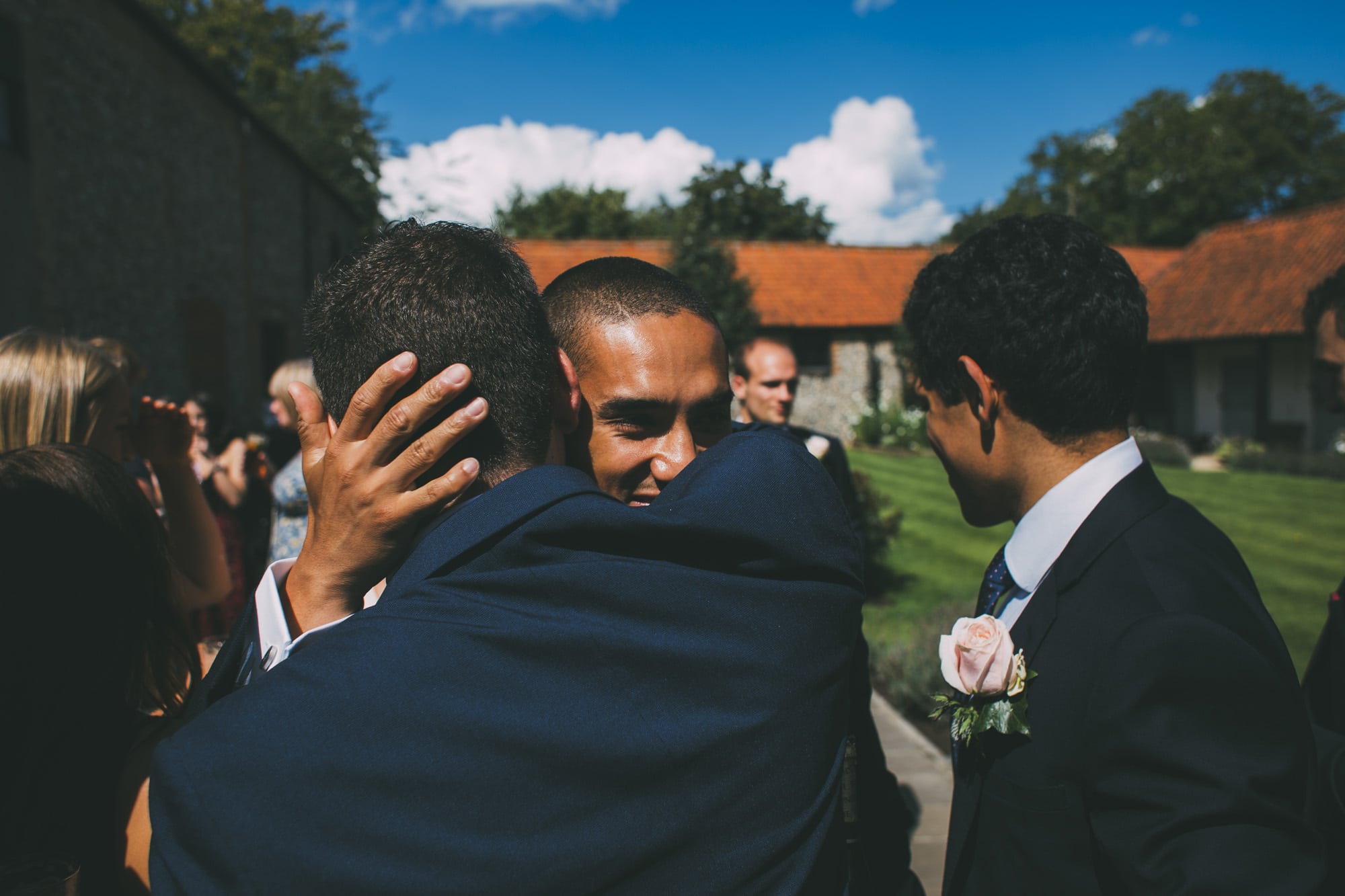 groom hugs wedding guest