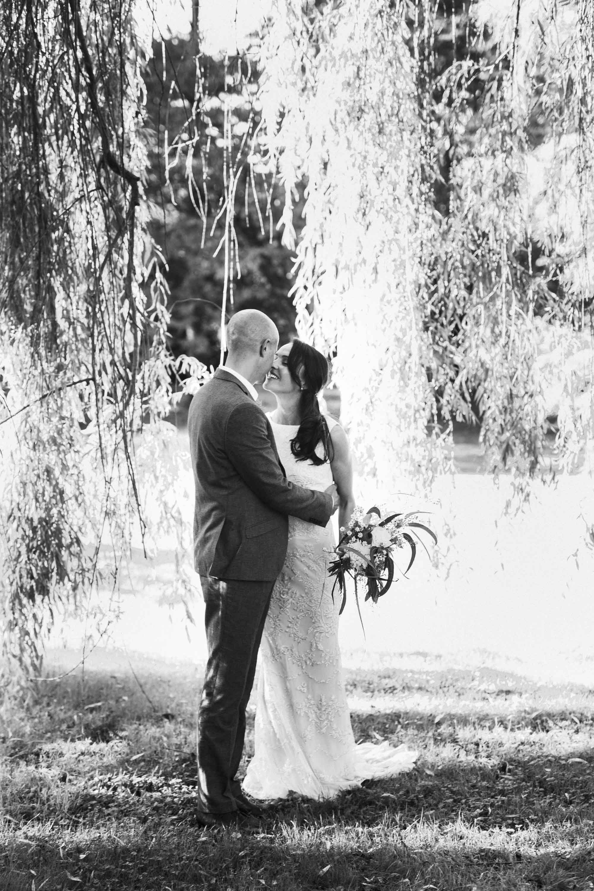 bride and groom under willow tree at nether winchendon house
