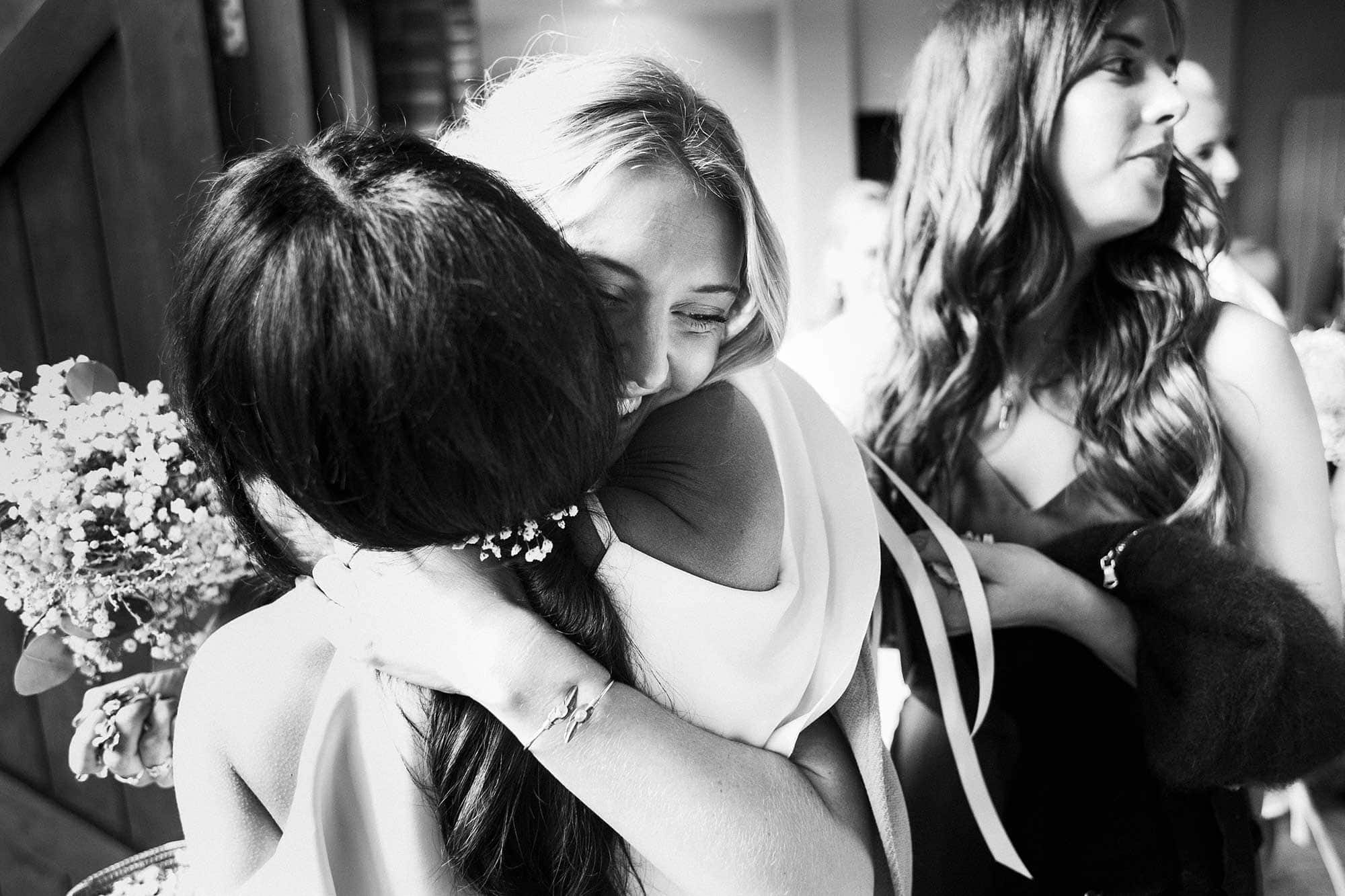 bridesmaids hug and laugh
