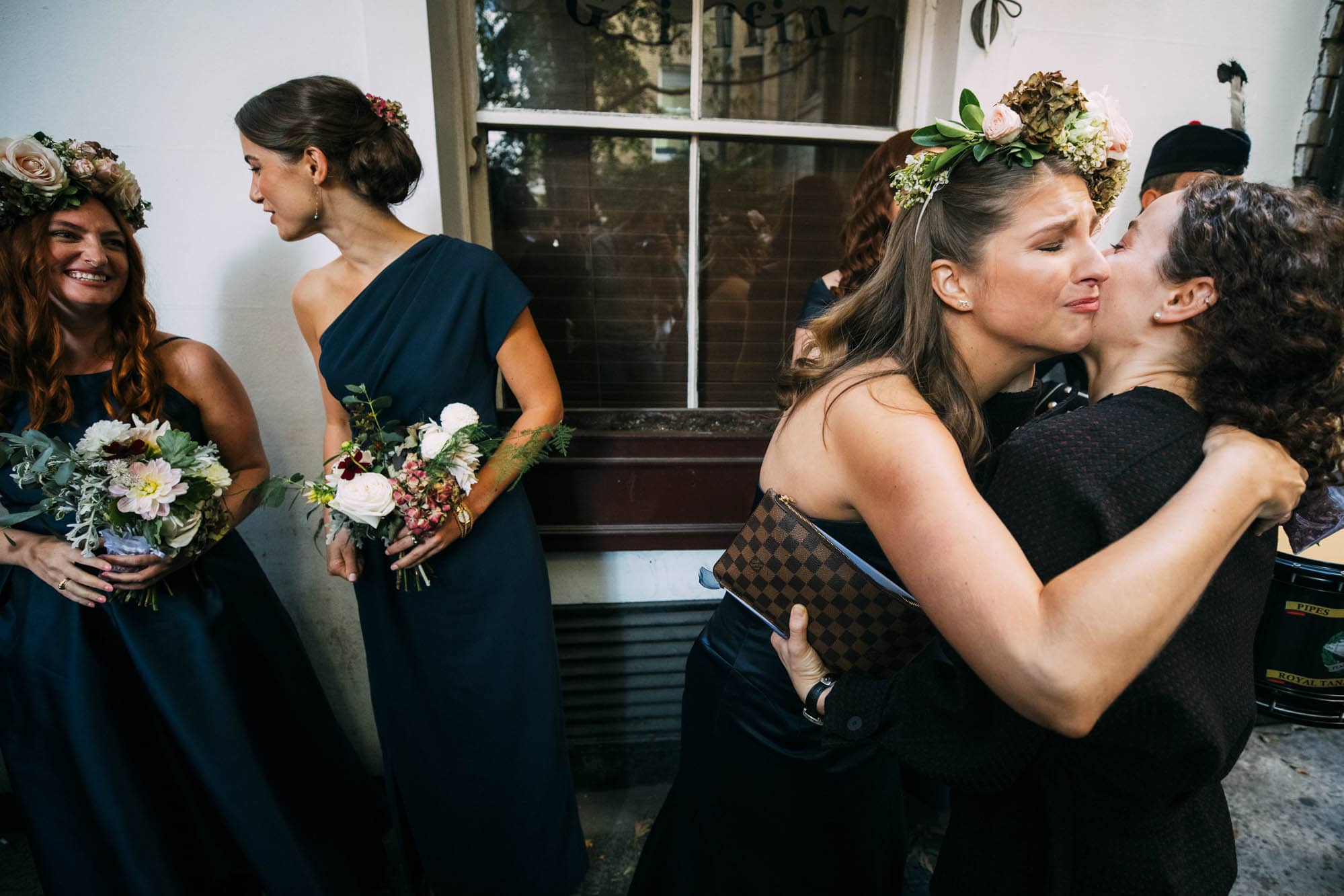 bridesmaids embrace wedding guest