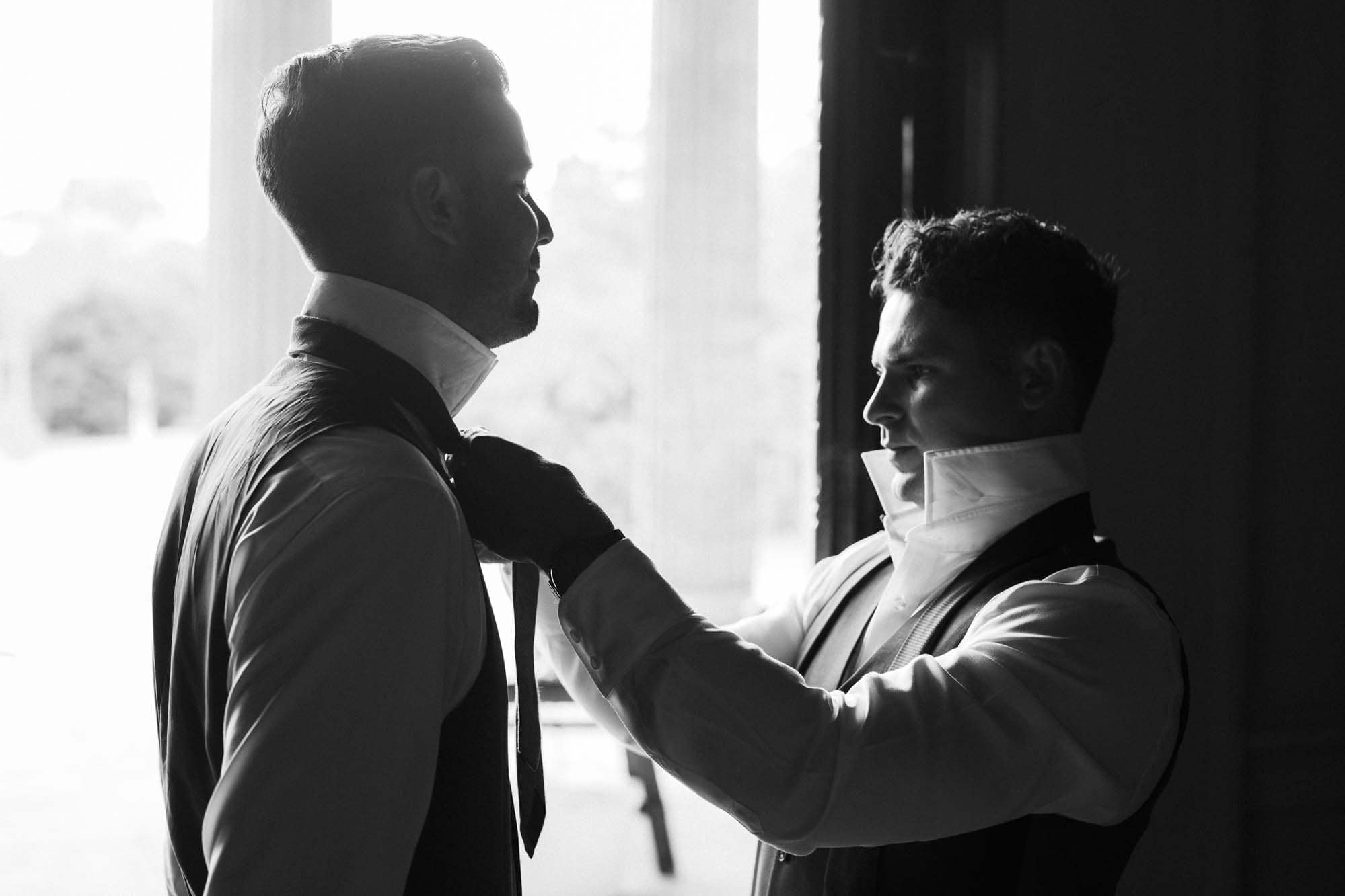 groomsmen putting on ties