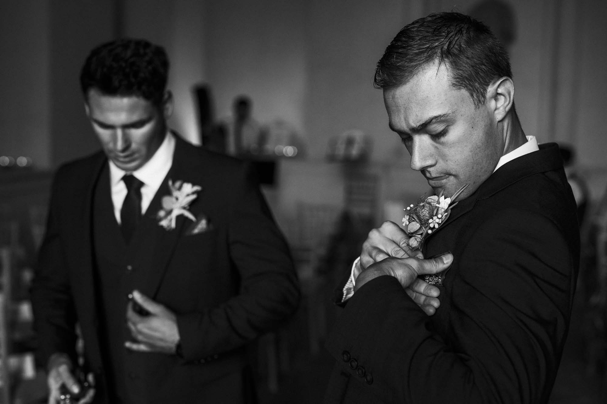groomsmen putting on buttonholes