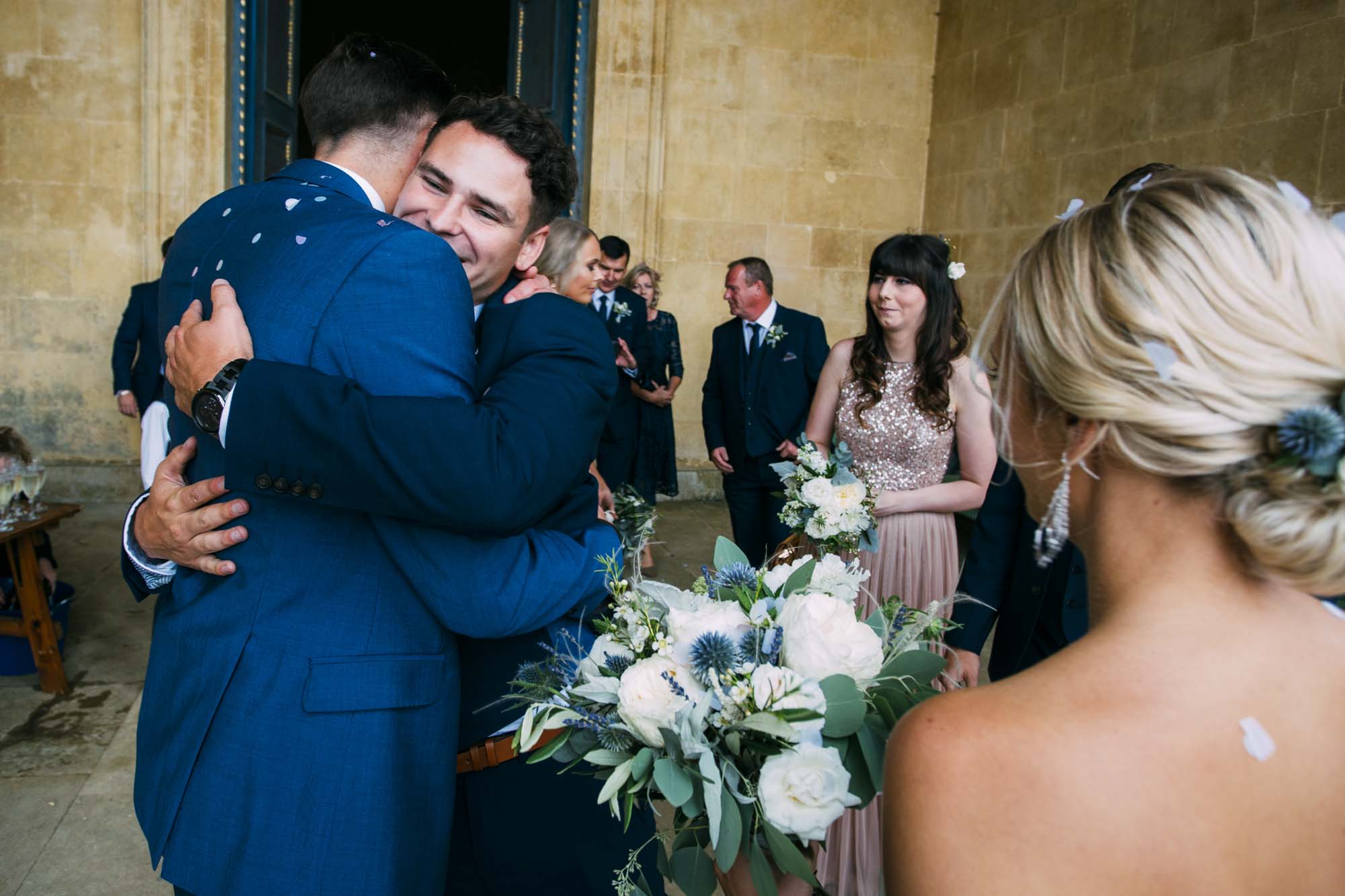 wedding guests hug groom