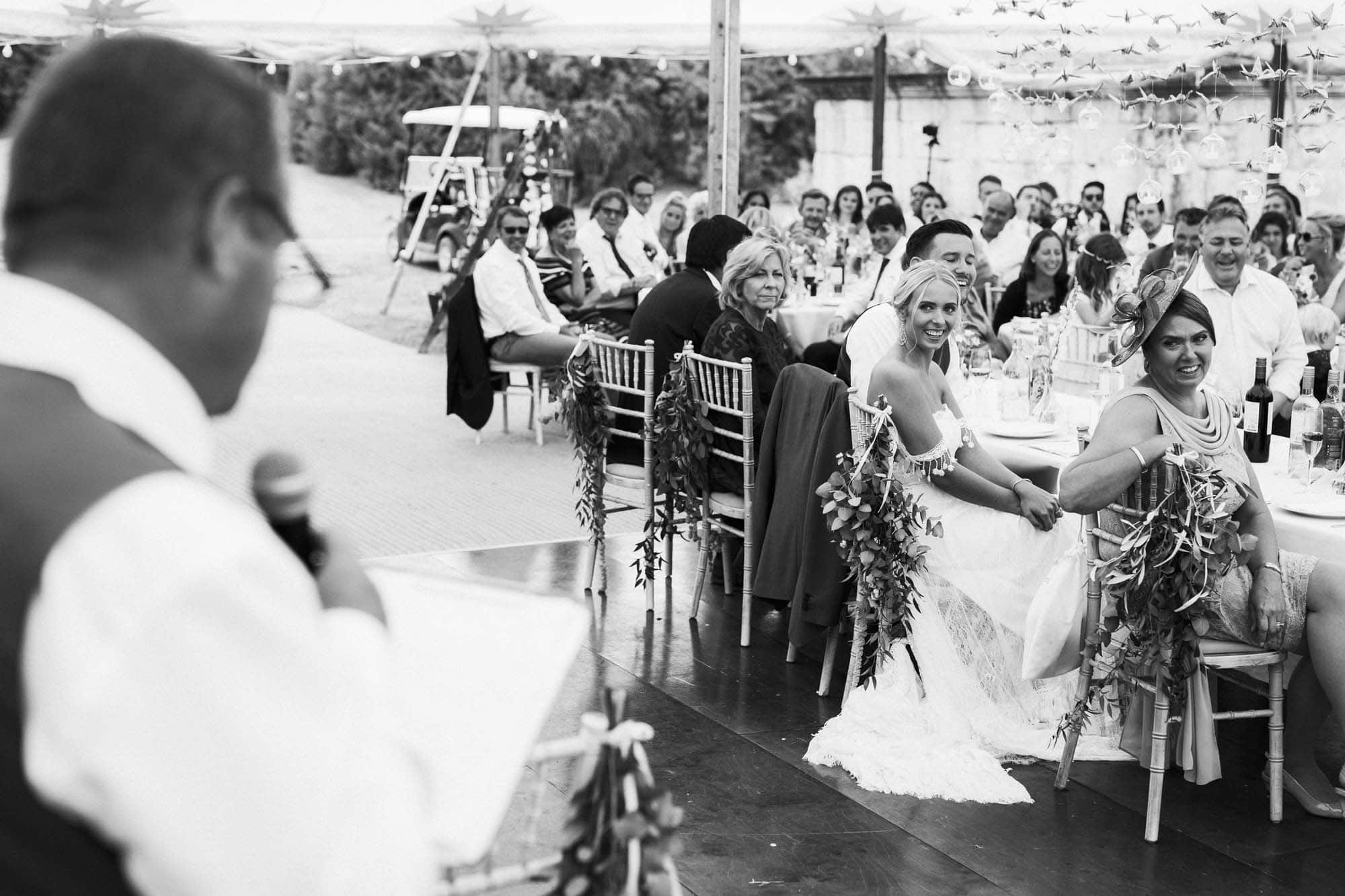 bride smiels during wedding speech