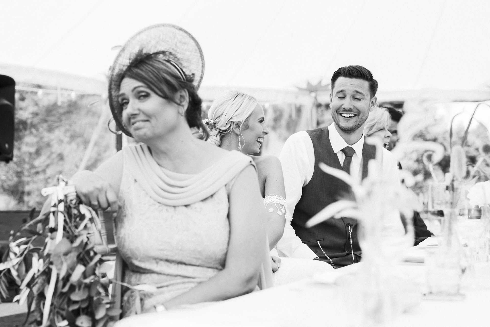 bride and groom laugh during wedding speech