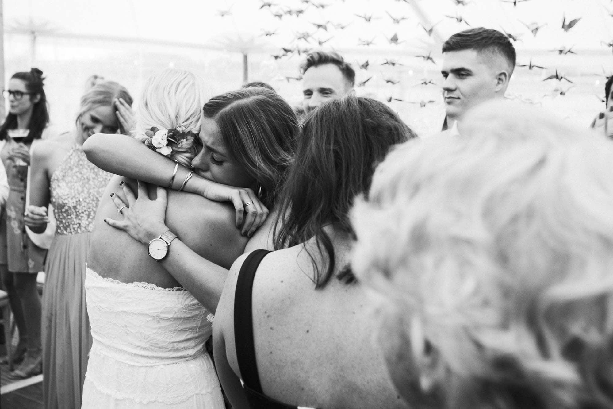 wedding guests hug on dancefloor