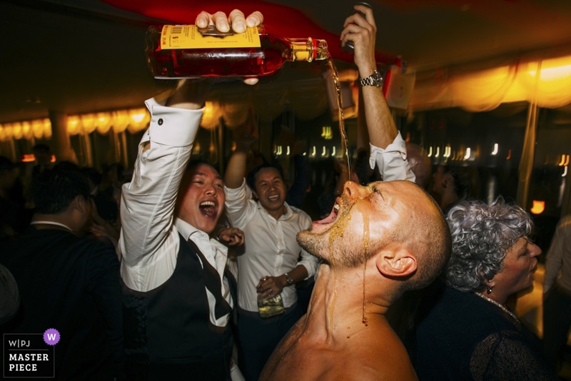 groom pouring rink on usher at london wedding party